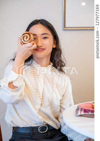 A young woman happily eating bread 127977169