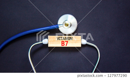 Vitamin B7 biotin symbol. Concept words Vitamin B7 on beautiful wooden block. Stethoscope. Beautiful black background. Medical healthy lifestyle Vitamin B7 concept. 127977290