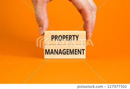 Property management symbol. Concept words Property management on wooden blocks on a beautiful orange table orange background. Businessman hand. Business property management concept. Copy space. 127977302