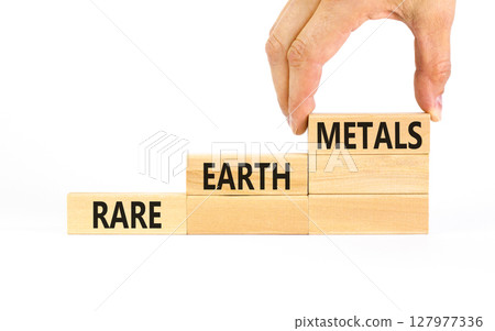 Rare earth metals symbol. Concept words Rare earth metals on beautiful wooden block. Businessman's hand. Beautiful white background. Business and rare earth metals concept. Copy space. 127977336