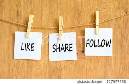 Like share follow symbol. Concept words Like Share Follow on beautiful white paper on clothespin. Beautiful wooden background. Business like share follow concept. Copy space. 127977368