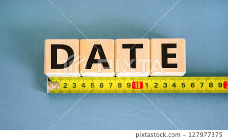 Date symbol. Concept word Date on beautiful wooden blocks. Beautiful yellow ruler. Beautiful blue table blue background. Business and date concept. Copy space. Date symbol. Concept word Date on beautiful wooden blocks. Beautiful yellow ruler. Beautiful blue table blue background. Business and date concept. Copy space. 127977375