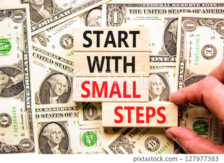 Start with small steps symbol. Concept words phrase Start with small steps on beautiful blocks. Dollar bills. Beautiful dollar bills background. Business Start with small steps concept. Copy space Start with small steps symbol. Concept words phrase Start with small steps on beautiful blocks. Dollar bills. Beautiful dollar bills background. Business Start with small steps concept. Copy space 127977383