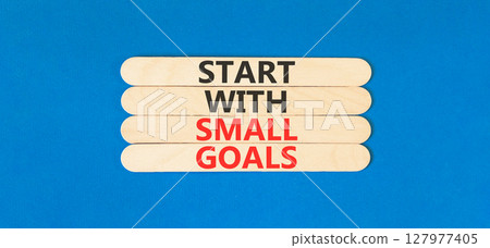 Start with small goals symbol. Concept words phrase Start with small goals on beautiful wooden stick. Beautiful blue paper background. Business Start with small goals concept. Copy space. 127977405