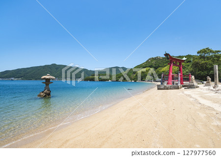 The large torii gate of Itsukushima Shrine on Iwako Island and a stone lantern standing in the sea, Onomichi City, Hiroshima Prefecture 127977560