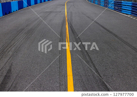 Abstract asphalt street road background with black tire marks on race track, Texture and background car automobile and automotive skid tire marks. 127977700