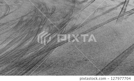 Abstract asphalt street road background with black tire marks on race track, Texture and background car automobile and automotive skid tire marks. 127977704