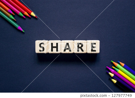 Share symbol. Concept word Share on beautiful wooden blocks. Beautiful black table black background. Beautiful colored pencils. Business lifestyle share concept. Copy space. 127977749
