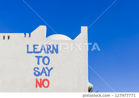 Learn to say no symbol. Concept words phrase Learn to say no on beautiful white wall. Beautiful white wall and blue sky background. Business psychological Learn to say no concept. Copy space. 127977771