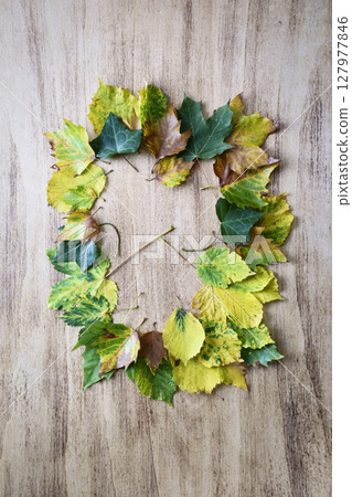 Composition of fallen leaves on a wooden antique table Composition of fallen leaves on a wooden antique table 127977846