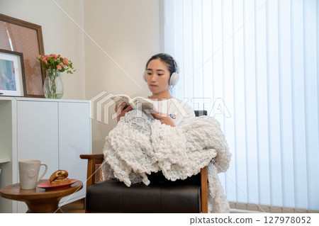 Young woman relaxing under a blanket 127978052
