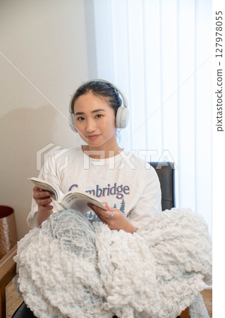 Young woman relaxing under a blanket Young woman relaxing under a blanket 127978055