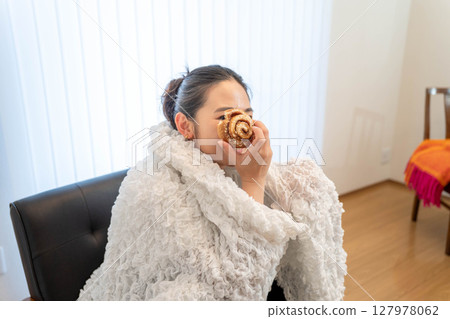 Young woman relaxing under a blanket Young woman relaxing under a blanket 127978062