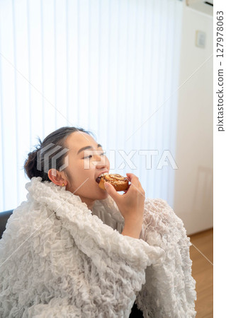 Young woman relaxing under a blanket 127978063