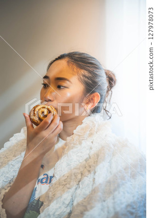 Young woman relaxing under a blanket Young woman relaxing under a blanket 127978073