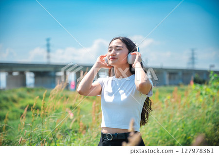 在智慧型手機上聽音樂的女人 在智慧型手機上聽音樂的女人 127978361