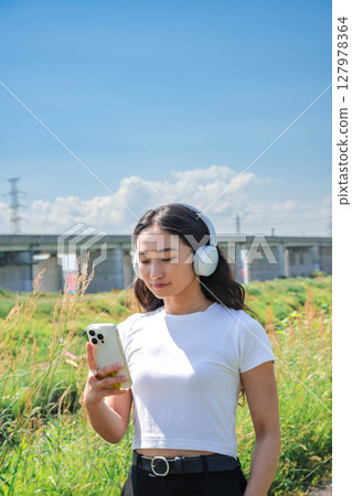 在智慧型手機上聽音樂的女人 127978364