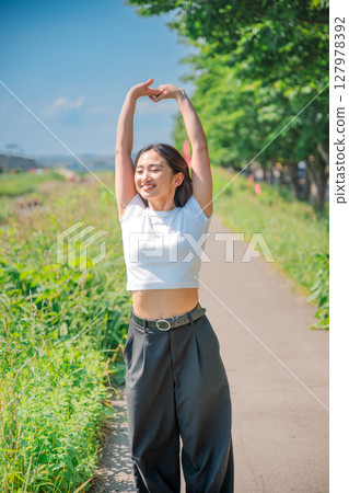Young woman relaxing under the blue sky Young woman relaxing under the blue sky 127978392