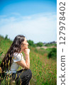 Young woman relaxing under the blue sky 127978402