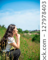 Young woman relaxing under the blue sky 127978403