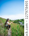 Young woman relaxing under the blue sky 127978405