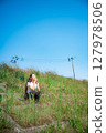 Young woman relaxing under the blue sky 127978506