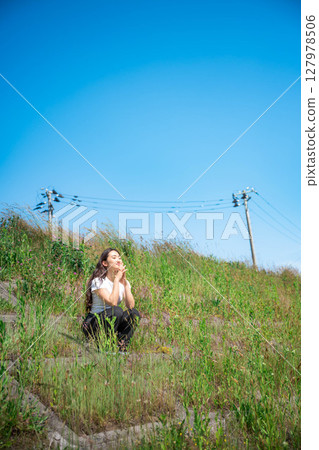 Young woman relaxing under the blue sky 127978506
