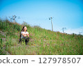 Young woman relaxing under the blue sky 127978507