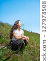 Young woman relaxing under the blue sky 127978508