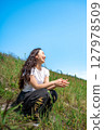 Young woman relaxing under the blue sky 127978509