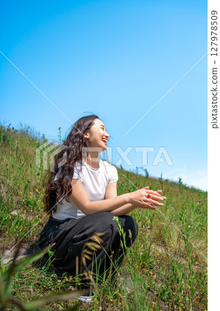 Young woman relaxing under the blue sky 127978509