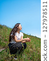 Young woman relaxing under the blue sky 127978511