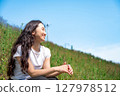 Young woman relaxing under the blue sky 127978512