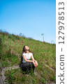 Young woman relaxing under the blue sky 127978513