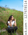 Young woman relaxing under the blue sky 127978514