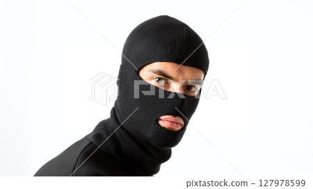 Person wearing a black knitted balaclava looking directly at the camera against a plain white background. Only their eyes and mouth are visible. 127978599