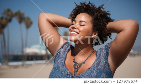 Woman enjoying sunshine on the beach, embracing the warmth and freedom. Her relaxed posture and joyful expression capture a moment of carefree bliss. 127978674