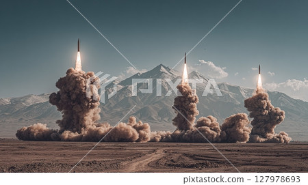 Multiple rockets launching in a desert, with mountains in background. Explosions billowing out from under rockets. 127978693
