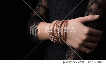 Golden Bracelets Adorned on Wrist: Exquisite wrist adorned with a collection of glimmering golden bracelets, set against a backdrop of intricate dark lace. Golden Bracelets Adorned on Wrist: Exquisite wrist adorned with a collection of glimmering golden bracelets, set against a backdrop of intricate dark lace. 127978860