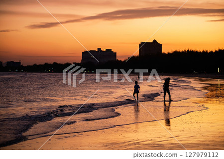 Silhouette family walk on Cha Am beach with beautiful sunset 127979112