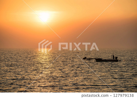 Silhouette fisherman sail motor boat on sea to fishing at sunset Silhouette fisherman sail motor boat on sea to fishing at sunset 127979138