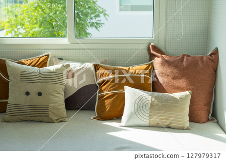 Modern stylish bedroom with brown and leather pillows setting. Large art piece on wall. 127979317