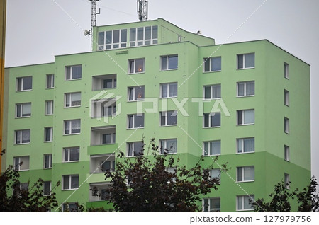 Original prefabricated houses on a housing estate from the communist era in Eastern and Central Europe after reconstruction.. Facade of a modern apartment building with windows and balconies. Czech 127979756
