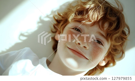 happy redhead boy with freckles lying down 127979855