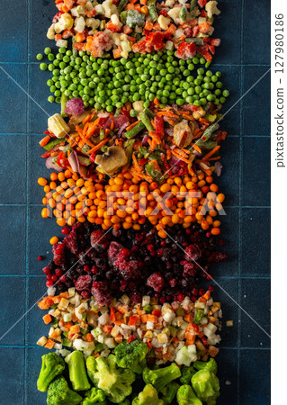 Bright, colorful background of frozen fruits and vegetables, symbolizing the concept of preparing healthy, organic produce for the winter season with vibrant, eco-friendly freezing 127980186