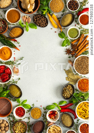 A lively frame of assorted herbs and spices on gray, highlighting the vibrant colors and flavors for cooking inspiration, top view and copy space A lively frame of assorted herbs and spices on gray, highlighting the vibrant colors and flavors for cooking inspiration, top view and copy space 127980188
