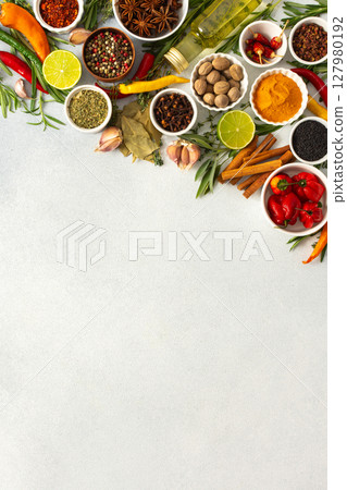 Colorful herbs and spices scattered across a gray surface, ideal for creating authentic and flavorful dishes, top view and copy space 127980192