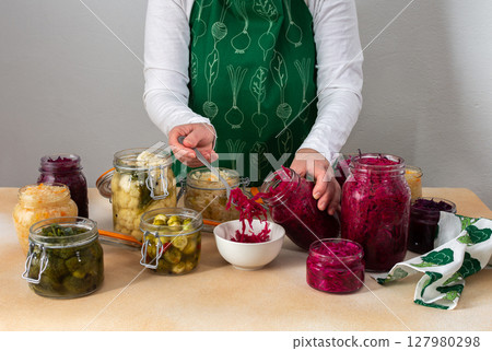 Woman fermenting fresh vegetables Woman fermenting fresh vegetables 127980298
