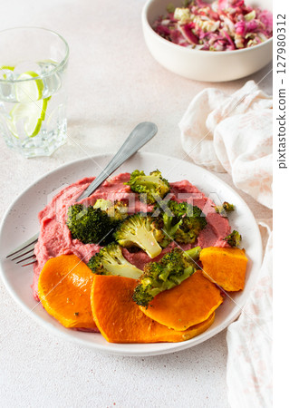A wholesome breakfast with beet hummus, baked sweet potato, and a fresh radish and cabbage salad, rich in vitamins, fiber, and protein A wholesome breakfast with beet hummus, baked sweet potato, and a fresh radish and cabbage salad, rich in vitamins, fiber, and protein 127980312
