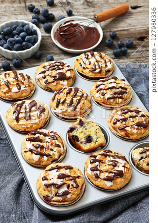 tasty blueberry muffins with lemon chocolate glaze 127980336